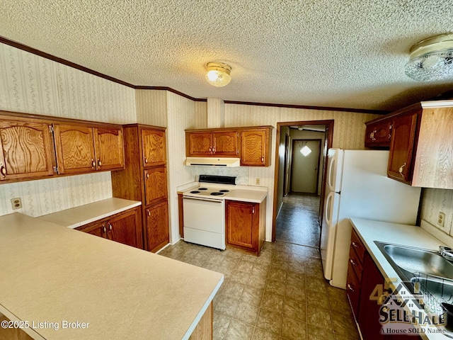 kitchen featuring white appliances, a textured ceiling, light countertops, and wallpapered walls