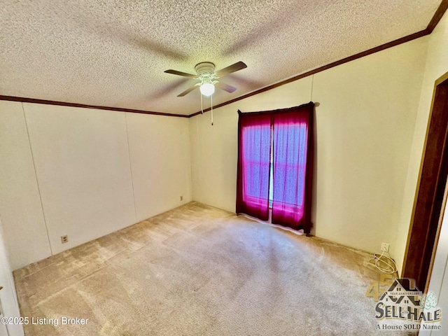 spare room with a textured ceiling, carpet flooring, ceiling fan, and ornamental molding