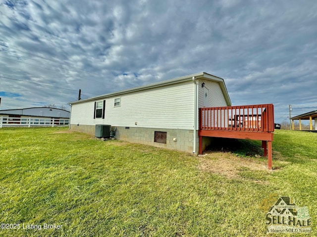 view of side of home with crawl space, a deck, cooling unit, and a yard