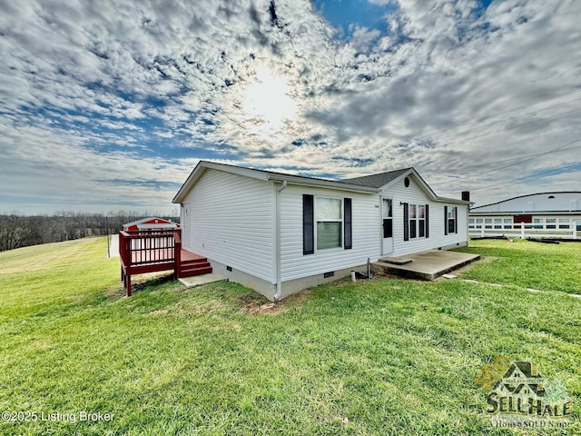 view of side of home with a wooden deck, a lawn, and crawl space