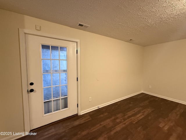 doorway to outside featuring visible vents, baseboards, dark wood-style flooring, and a textured ceiling