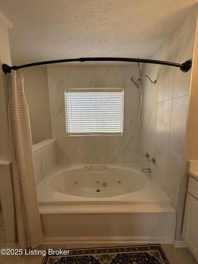 bathroom featuring vanity, a combined bath / shower with jetted tub, and a textured ceiling