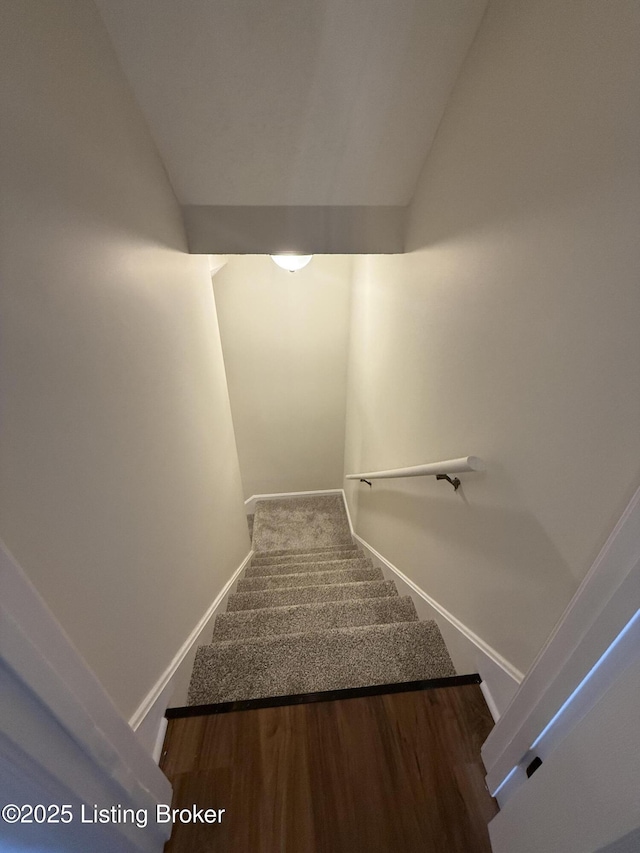 stairway with baseboards and vaulted ceiling