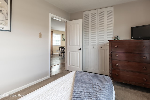 bedroom with a closet, baseboards, and carpet flooring