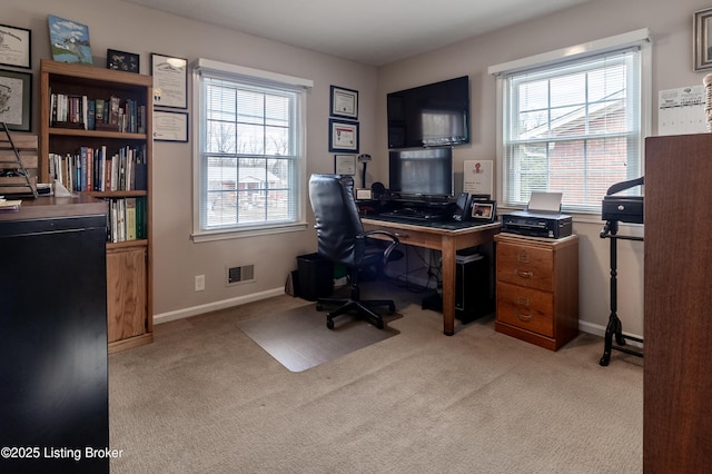 carpeted office featuring visible vents, baseboards, and a healthy amount of sunlight