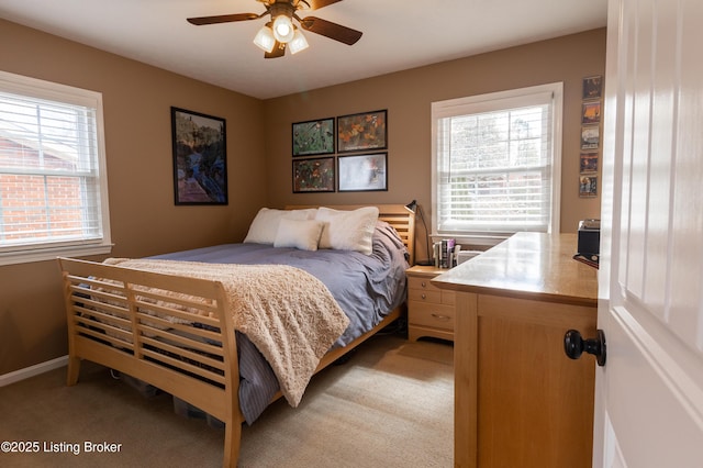 bedroom featuring baseboards, multiple windows, and light colored carpet