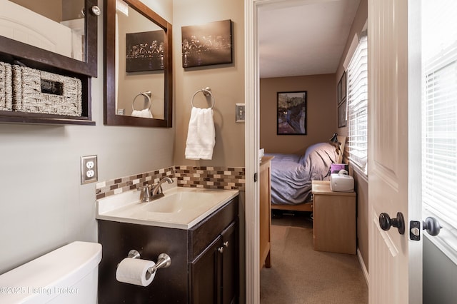 half bathroom with tasteful backsplash, toilet, ensuite bath, and vanity