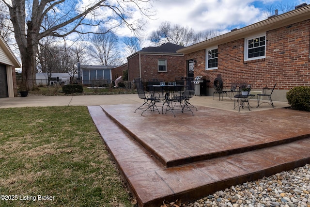 wooden terrace with a patio area, grilling area, a lawn, and fence