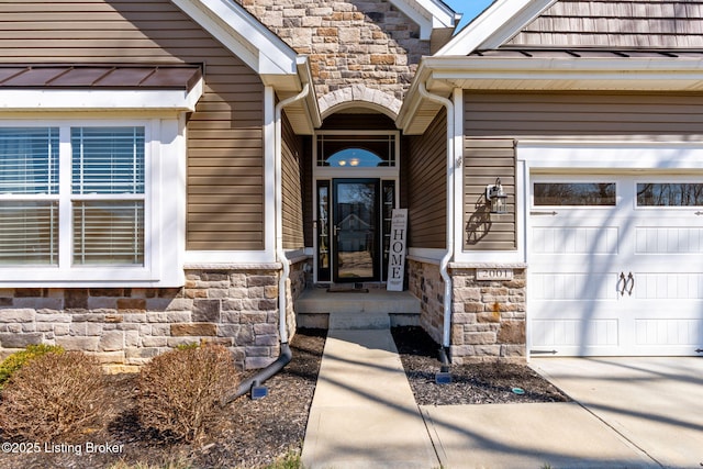 entrance to property featuring stone siding and a garage