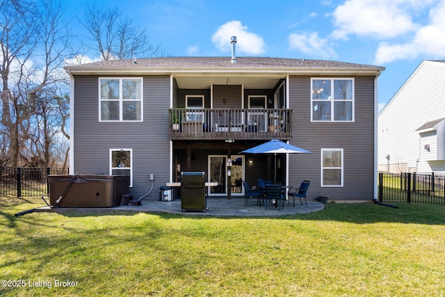 rear view of house with a patio, a balcony, a yard, a fenced backyard, and a hot tub