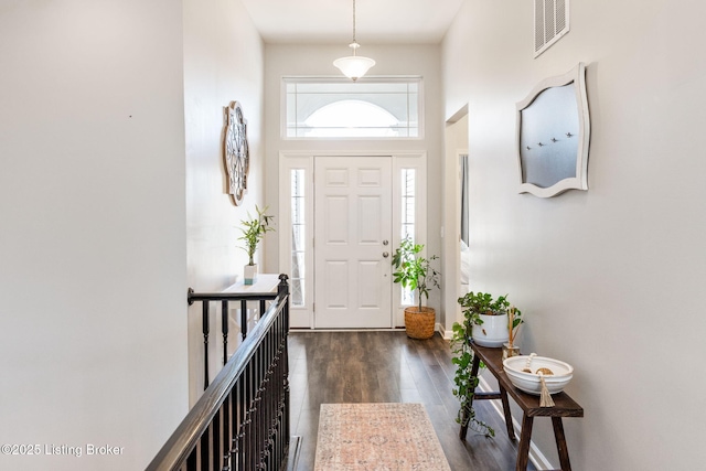 foyer entrance featuring dark wood-type flooring and visible vents