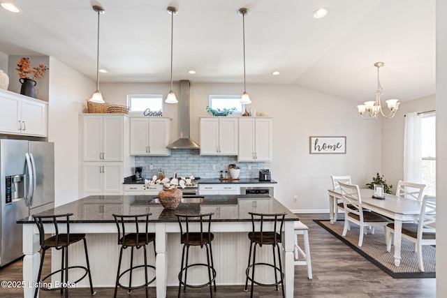 kitchen featuring dark wood-style floors, stainless steel fridge with ice dispenser, white cabinets, wall chimney exhaust hood, and tasteful backsplash