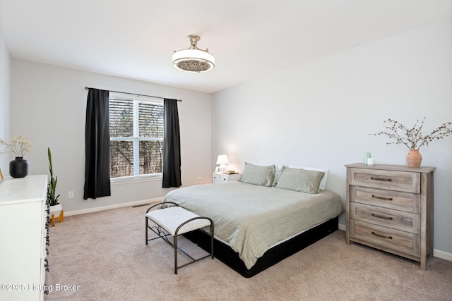 bedroom with light colored carpet and baseboards