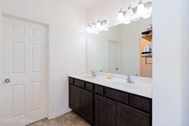 full bath featuring double vanity, baseboards, and a sink