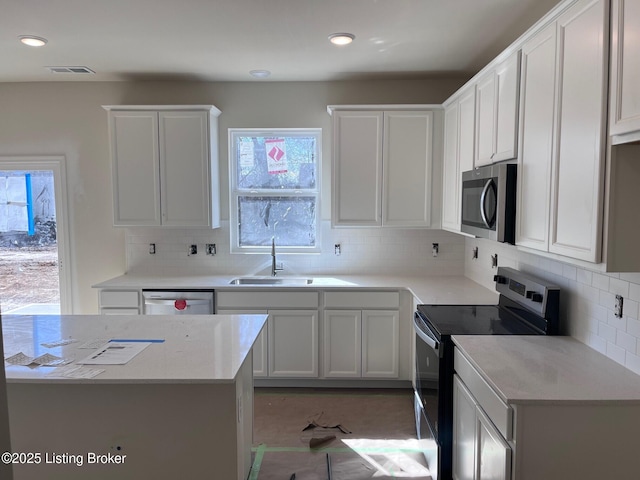 kitchen with visible vents, a sink, light countertops, white cabinets, and appliances with stainless steel finishes