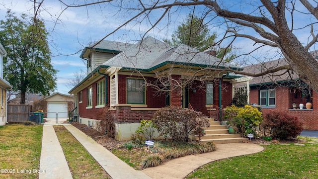 bungalow-style home featuring fence, driveway, an outdoor structure, a detached garage, and brick siding