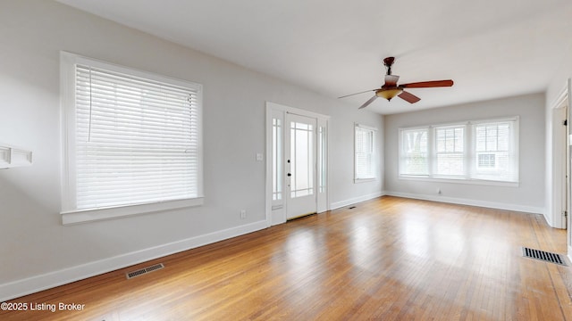 entryway featuring visible vents, ceiling fan, baseboards, and wood finished floors