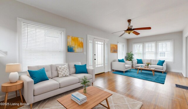 living room featuring a ceiling fan, wood finished floors, and baseboards