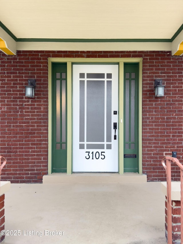 view of exterior entry with brick siding