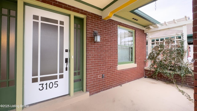 view of exterior entry with elevator and brick siding