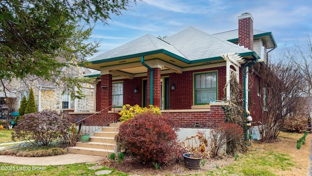 view of front facade with brick siding and a chimney