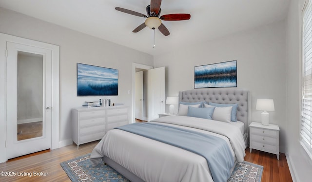 bedroom featuring a ceiling fan, wood finished floors, and baseboards