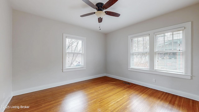 spare room featuring visible vents, baseboards, a ceiling fan, and light wood finished floors