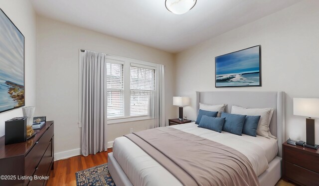 bedroom with baseboards and wood finished floors