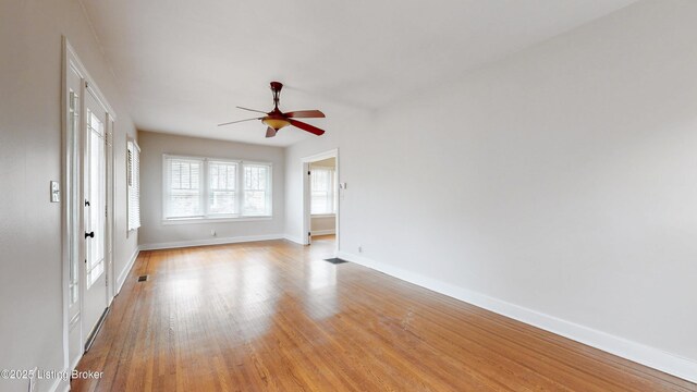 unfurnished room featuring a ceiling fan, visible vents, baseboards, and light wood-type flooring