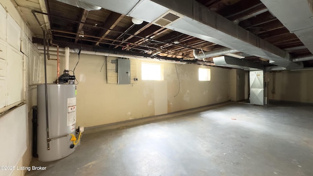 below grade area featuring water heater, heating unit, visible vents, and electric panel