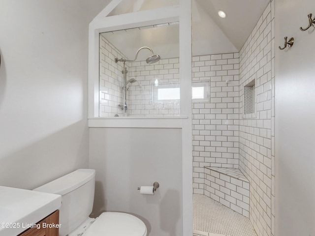 bathroom with tiled shower, toilet, and vanity