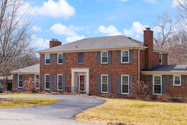 view of front of property featuring brick siding and a chimney