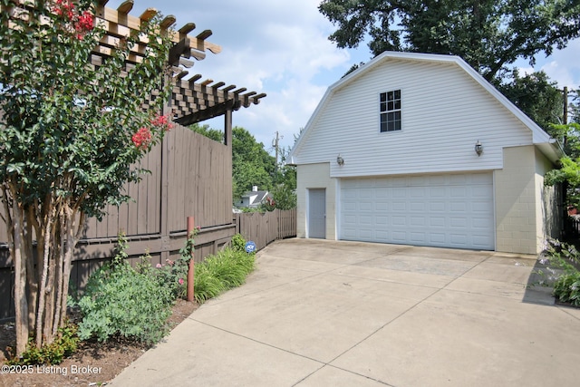 view of property exterior featuring an outbuilding, fence, a gambrel roof, a pergola, and a garage