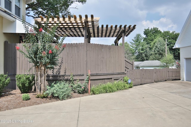 view of patio with driveway, a pergola, a garage, and fence