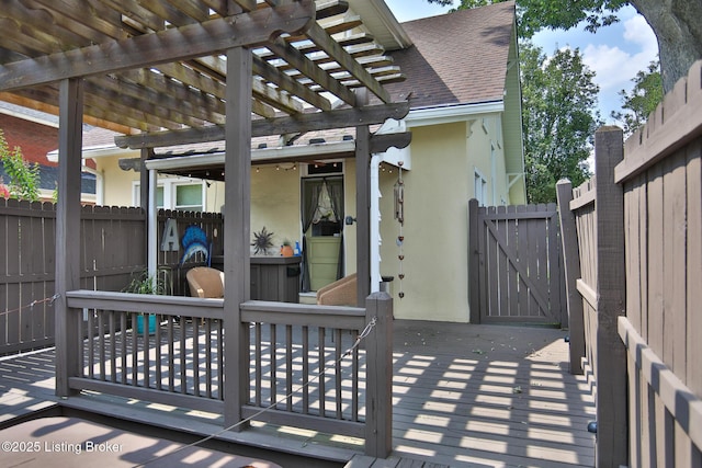 view of patio / terrace with a gate, a wooden deck, a pergola, and fence