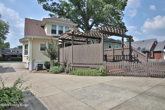 view of front of house featuring a residential view, stucco siding, a pergola, and fence