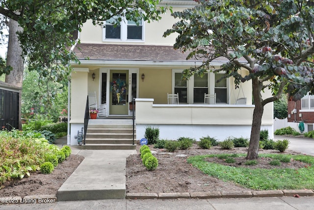 view of front of house featuring a porch, roof with shingles, and stucco siding