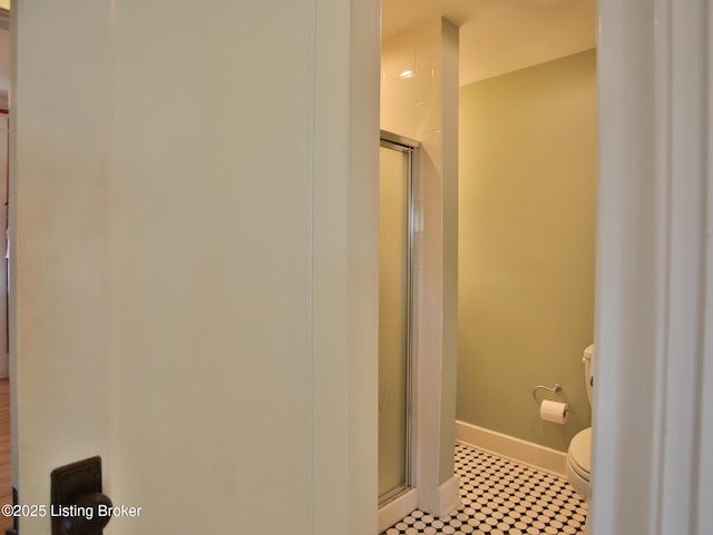 full bathroom with a shower with shower door, baseboards, toilet, and tile patterned floors