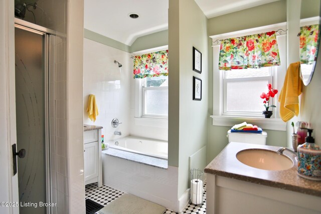 bathroom with vanity, tiled tub, and a tile shower