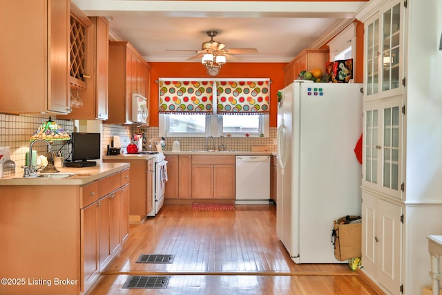 kitchen featuring visible vents, white appliances, light countertops, and a sink