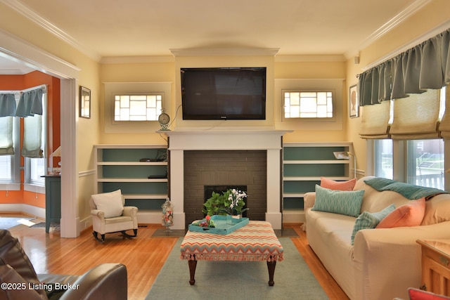 living area featuring ornamental molding, a fireplace, and wood finished floors