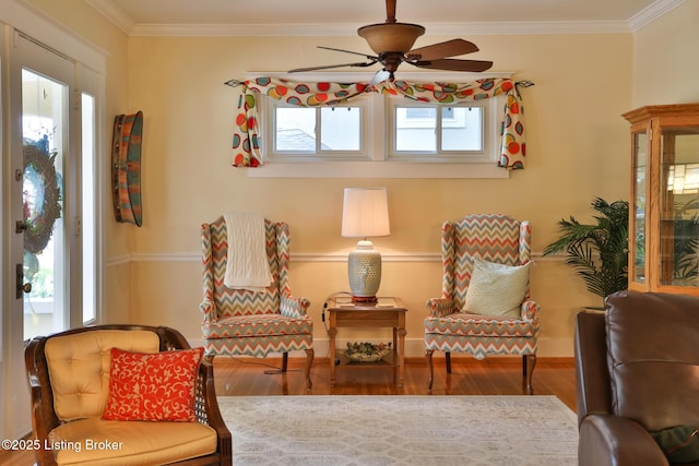 sitting room with a wealth of natural light, crown molding, and wood finished floors