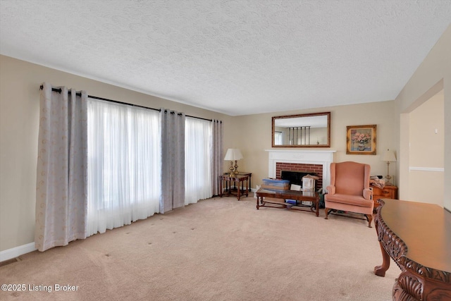 living area with carpet flooring, a fireplace, baseboards, and a textured ceiling