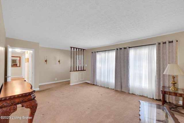 living room featuring baseboards, light carpet, and a textured ceiling