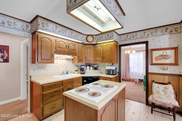 kitchen with wallpapered walls, light countertops, black dishwasher, and a sink