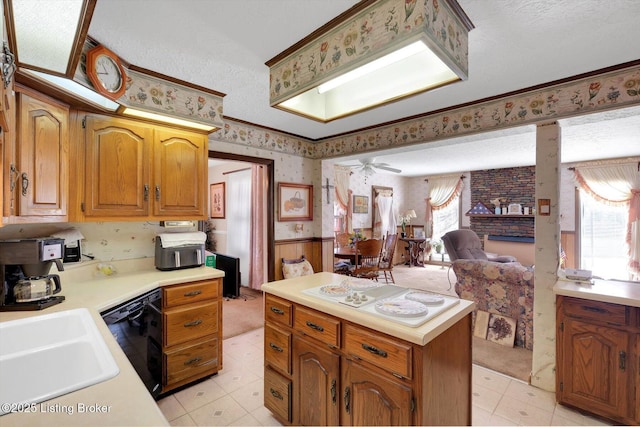 kitchen featuring wallpapered walls, a wainscoted wall, dishwasher, light countertops, and a sink