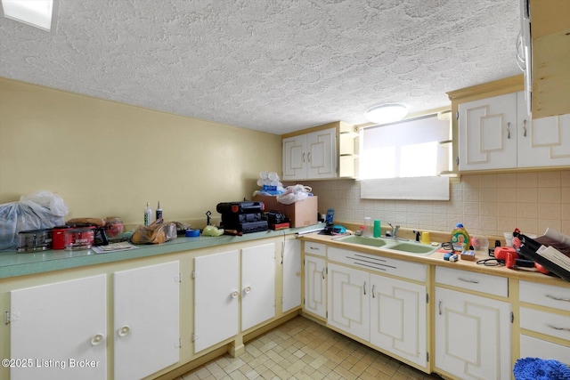 kitchen featuring a sink, tasteful backsplash, and light countertops