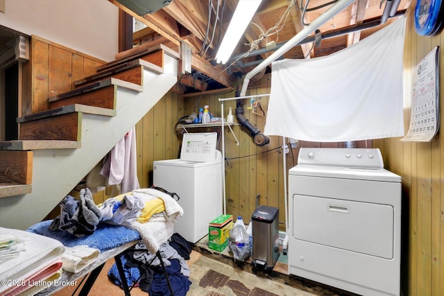 washroom featuring wood walls and washing machine and clothes dryer