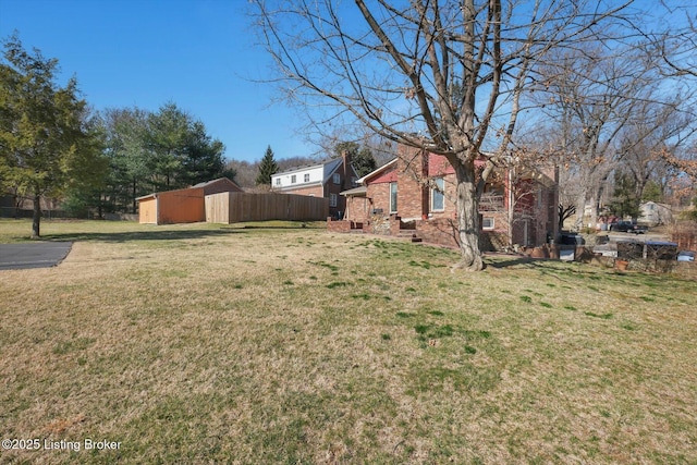 view of yard with an outbuilding and fence