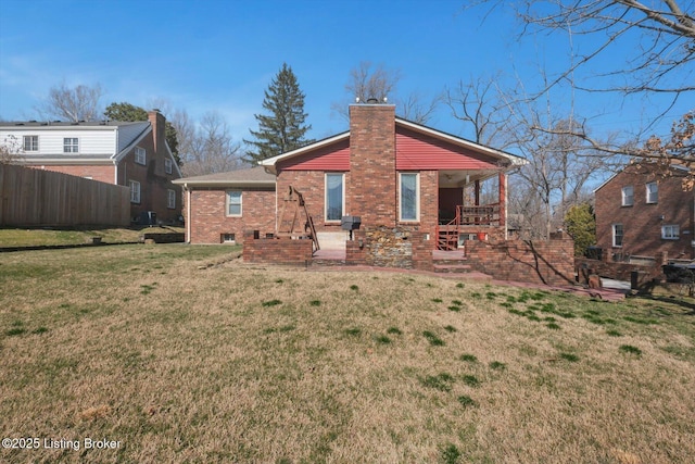 rear view of property with a patio, fence, a yard, a chimney, and brick siding